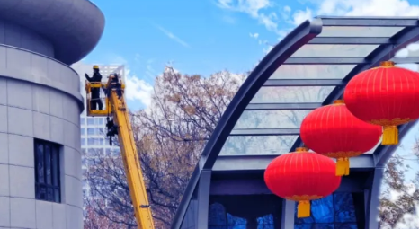 元宵节过后工人佩戴高空作业安全带摘灯笼