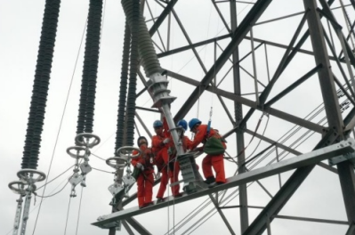 电力工人佩戴高空作业安全带和防坠器完成避雷器加装作业